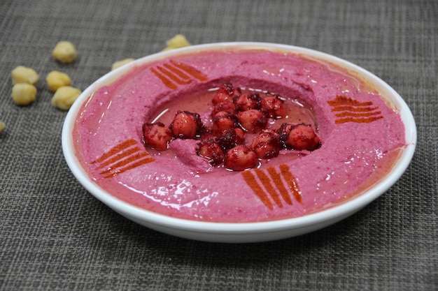 Beetroot Hummus served in a dish isolated on wooden table background side view of appetizer