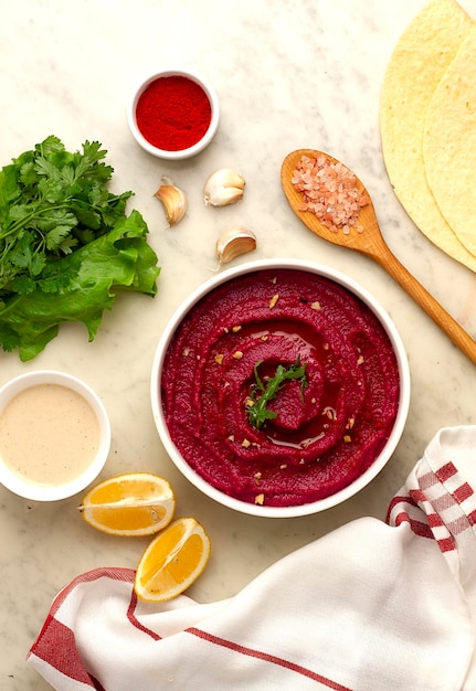 Beetroot hummus, with tahini, spices and olive oil, on a white table, no people, top view,. High quality photo