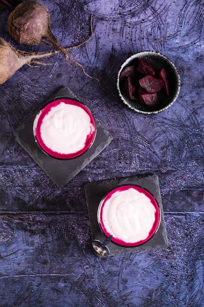 Beetroot latte in glasses and beetroot pieces in a bowl Coffee alternative Top and vertical view