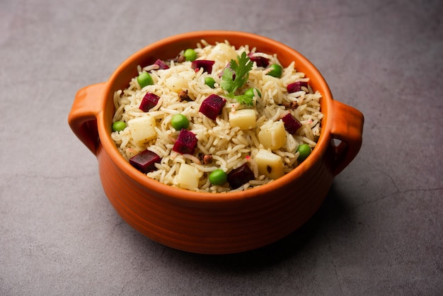 Beetroot Rice or pulao or pulav served in a bowl or karahi, selective focus. Indian food