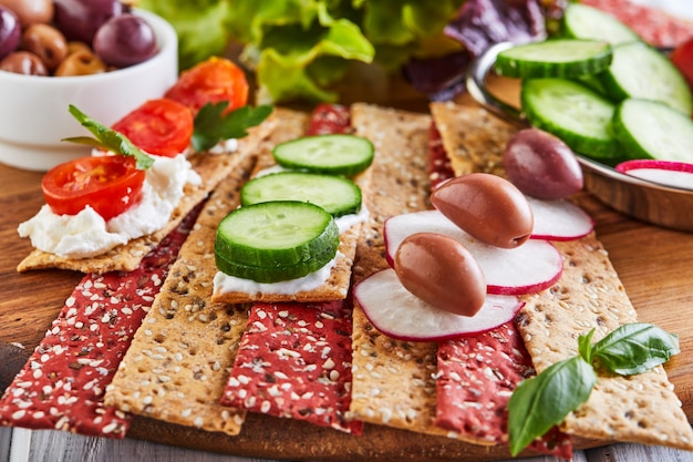 Beetroot and rye flour crackers with vegetables for making snacks on a wooden wall. Vegetarianism and healthy eating