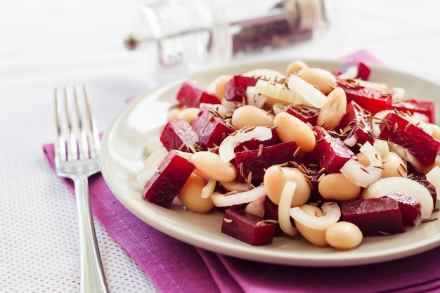 beetroot salad with white kidney beans pickles and onion dressed with oil with caraway seeds