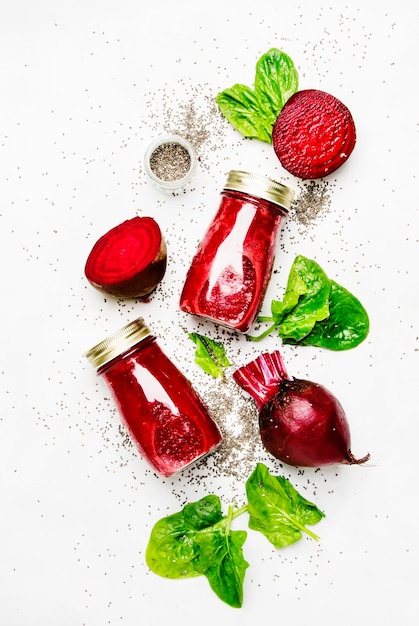 Beetroot smoothies with chia seeds glass bottles gray background top view