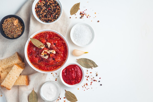 Beetroot soup with garlic, bread and spices on a white background. Cooking concept.