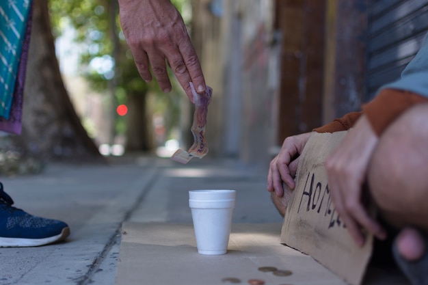 Beggar receiving money from a stranger