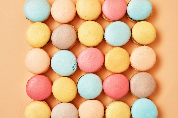 Beige, brown french cookies macarons on  yellow peach background