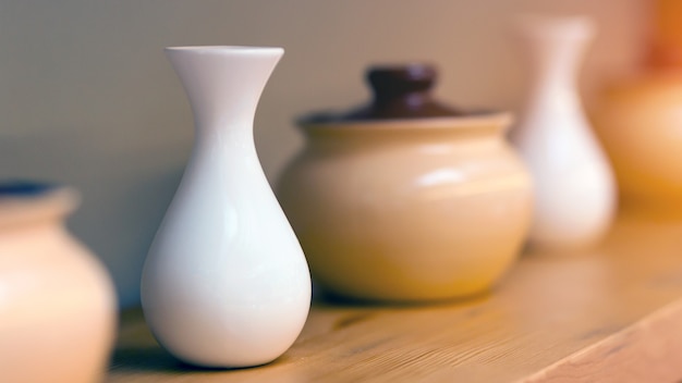 Beige ceramic pots and white small vases for color