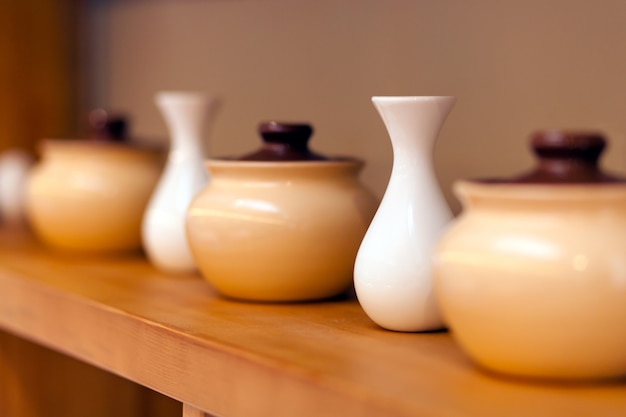 Beige ceramic pots and white small vases