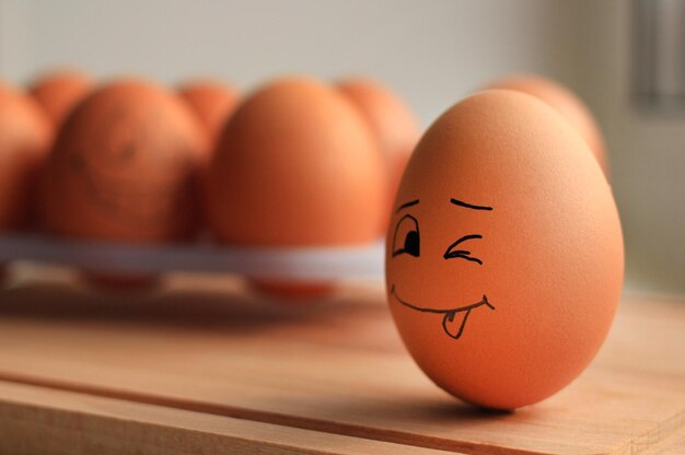 Beige chicken eggs with laughing face on egg stand