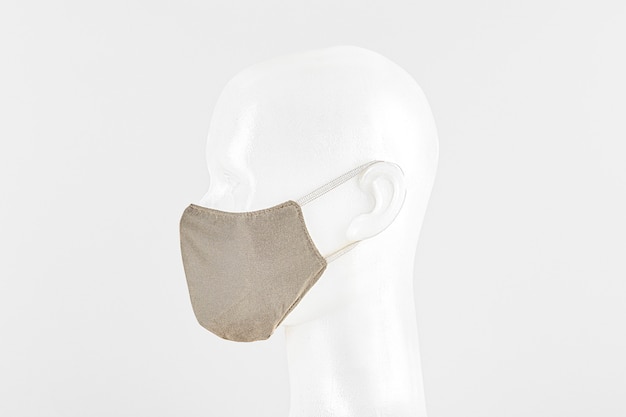 Beige fabric face mask on a dummy head