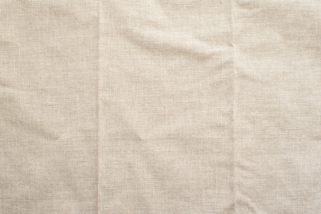 Beige natural linen fabric with folds close up