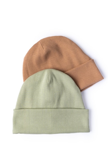 Beige and olive hats isolated on white background Stylish beanie hat cold protection concept