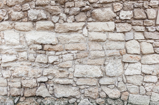 Beige rough stone rock wall. Texture, old style, background