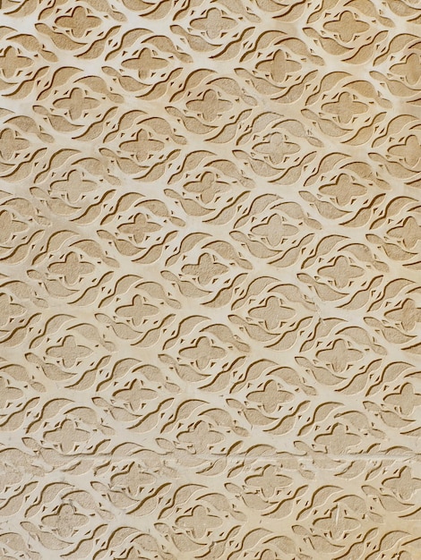 Beige stucco wall made in sgraffito technique with floral ornate downtown district of Toledo Spain