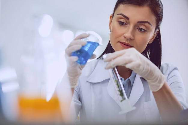 Being inspired. Content dark-haired researcher carrying out a test while working in the lab