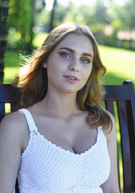 Belarus woman in white dress sitting on wooden swings