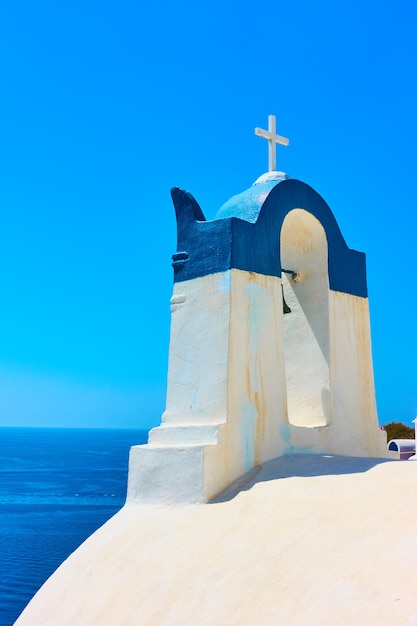 Belfry with cross in Oia town in Santorini, Greece