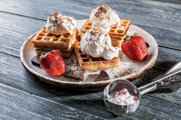 Belgian Wafers with vanilla ice cream, fresh strawberries and chocolate. Delicious breakfast.