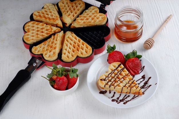 Belgian waffle with fresh strawberry honey and chocolate on white