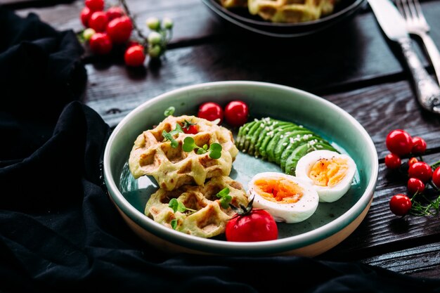 Belgian waffles with avocado egg and tomato Healthy breakfast