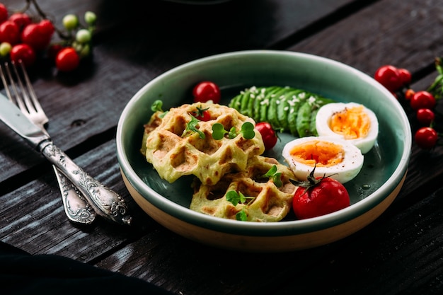 Belgian waffles with avocado egg and tomato Healthy breakfast