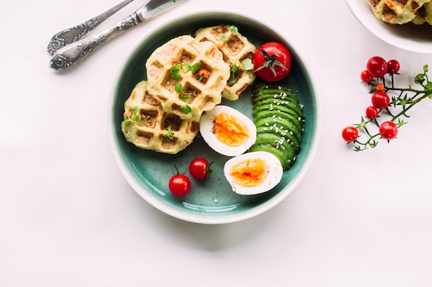 Belgian waffles with avocado egg and tomato Healthy breakfast