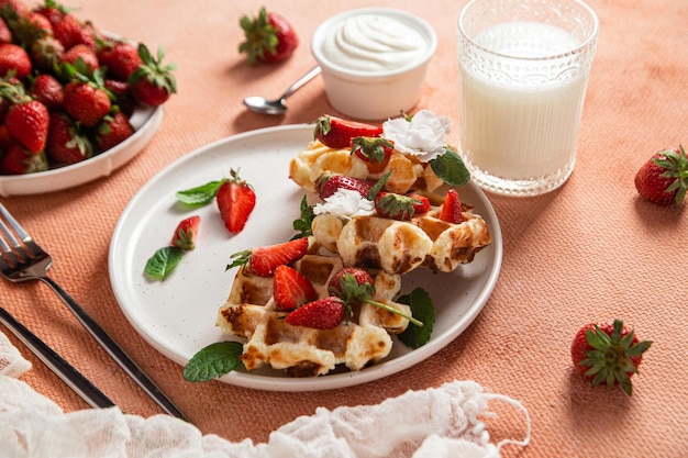 Photo belgian waffles with fresh strawberries in a plate viennese waffles