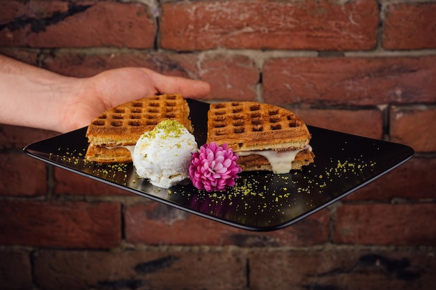 Belgian waffles with ice cream in black plate