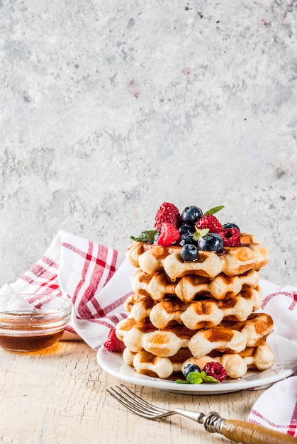 Belgian waffles with raspberries, blueberries and syrup, homemade healthy breakfast