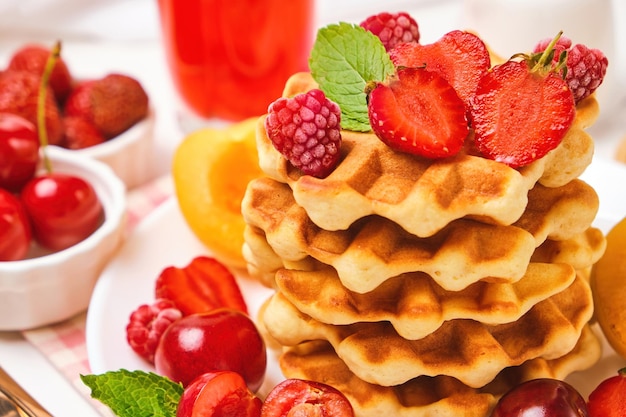 Belgian waffles with strawberries apricots cherries juice