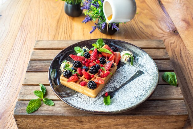 Belgian waffles with strawberries, blueberries, blackberries and syrup