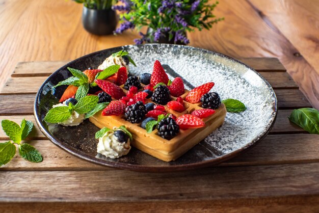 Belgian waffles with strawberries, blueberries, blackberries and syrup