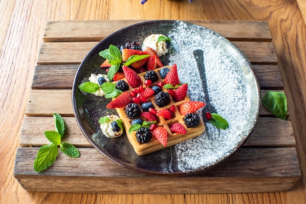 Belgian waffles with strawberries, blueberries, blackberries and syrup