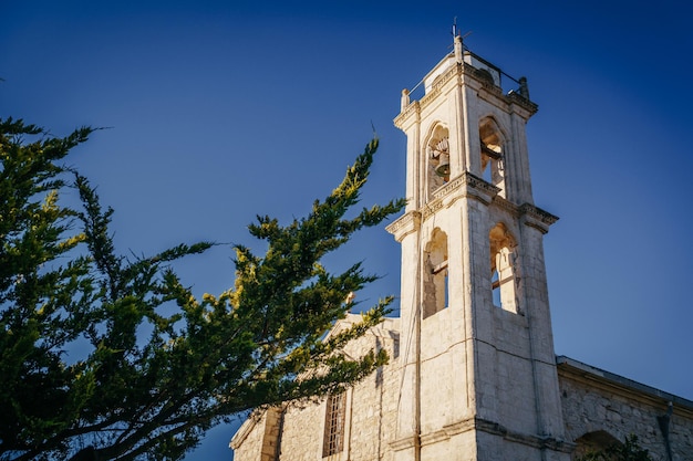 The bell tower of the old church against the blue sky