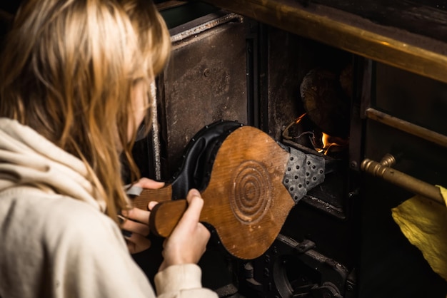 Bellows for kindling the fireplace A woman is lighting a stove