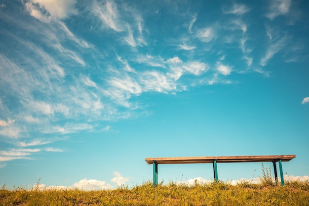 Bench against blue sky with light clouds Bottom view