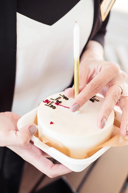 Bento cake with a candle with a girl's handcloseupLittle surprise for a girl's birthday