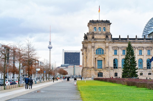 Berlin, Germany - December 8, 2017: Street at Reichstag building with German Flag in Berlin, capital of Germany in winter in the street. German Bundestag parliament house.