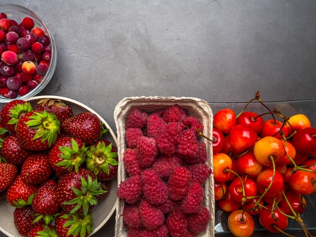 Berries on concrete Background Summer or Spring Organic Berry Strawberries Raspberries Cherry Cranberries Agriculture Gardening Harvest Concept