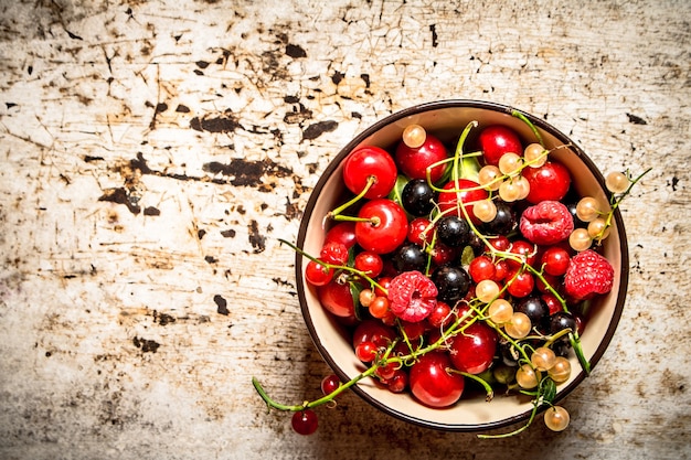 Berries in a Cup. On the rustic background.