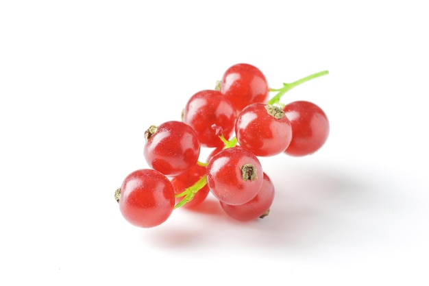 Berries of ripe tasty red currant isolated on white background. red currant with a leaf. a slide of red currants. Red currant berries with leaf isolated on white background.