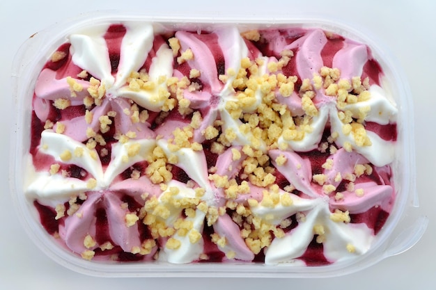 Berry cream dessert ice cream in a plastic box on a white background view from above