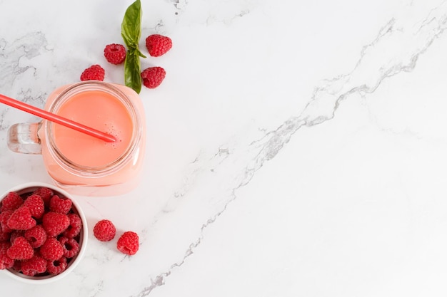 Berry smoothie in a glass jar on the breakfast with raspberries Top view with copy space