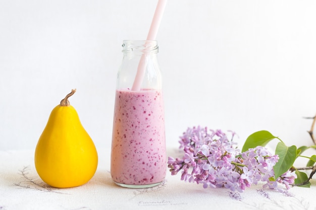 Berry smoothie in a glass jar with a straw