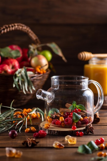 Berry tea Sea buckthorn and raspberries in a glass teapot cups with poured tea