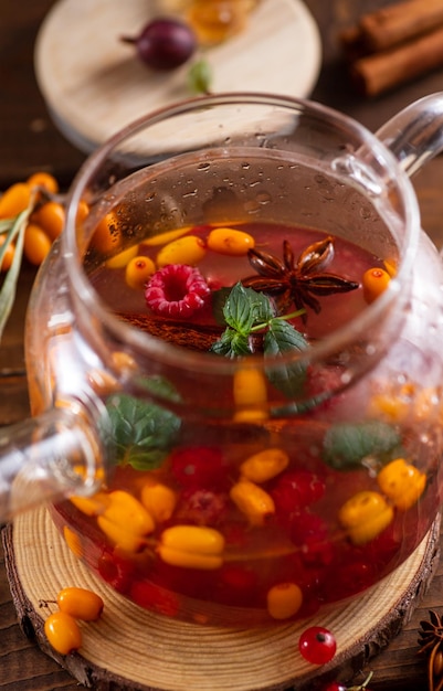 Berry tea Sea buckthorn and raspberries in a glass teapot cups with poured tea