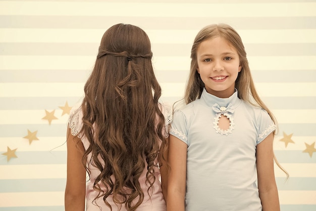 Best hairstyles for long hair Cute small girls with long brunette and blond curls in playroom Adorable little children long loose hair Enjoying long curly hairstyle