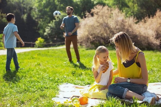 Best mother. Joyful loving mother sitting with her daughter and her husband playing with their son