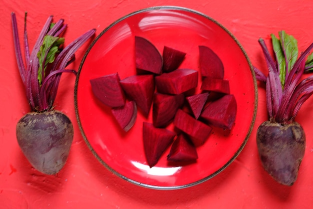 Photo beta vulgaris. sliced beetroot on a red plate. golden beet or red beet. red vegetables. buah bit.