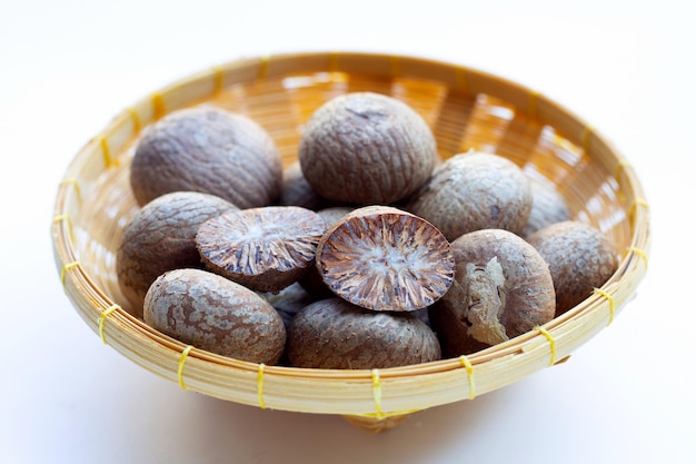 Betel nut in bamboo basket on white background